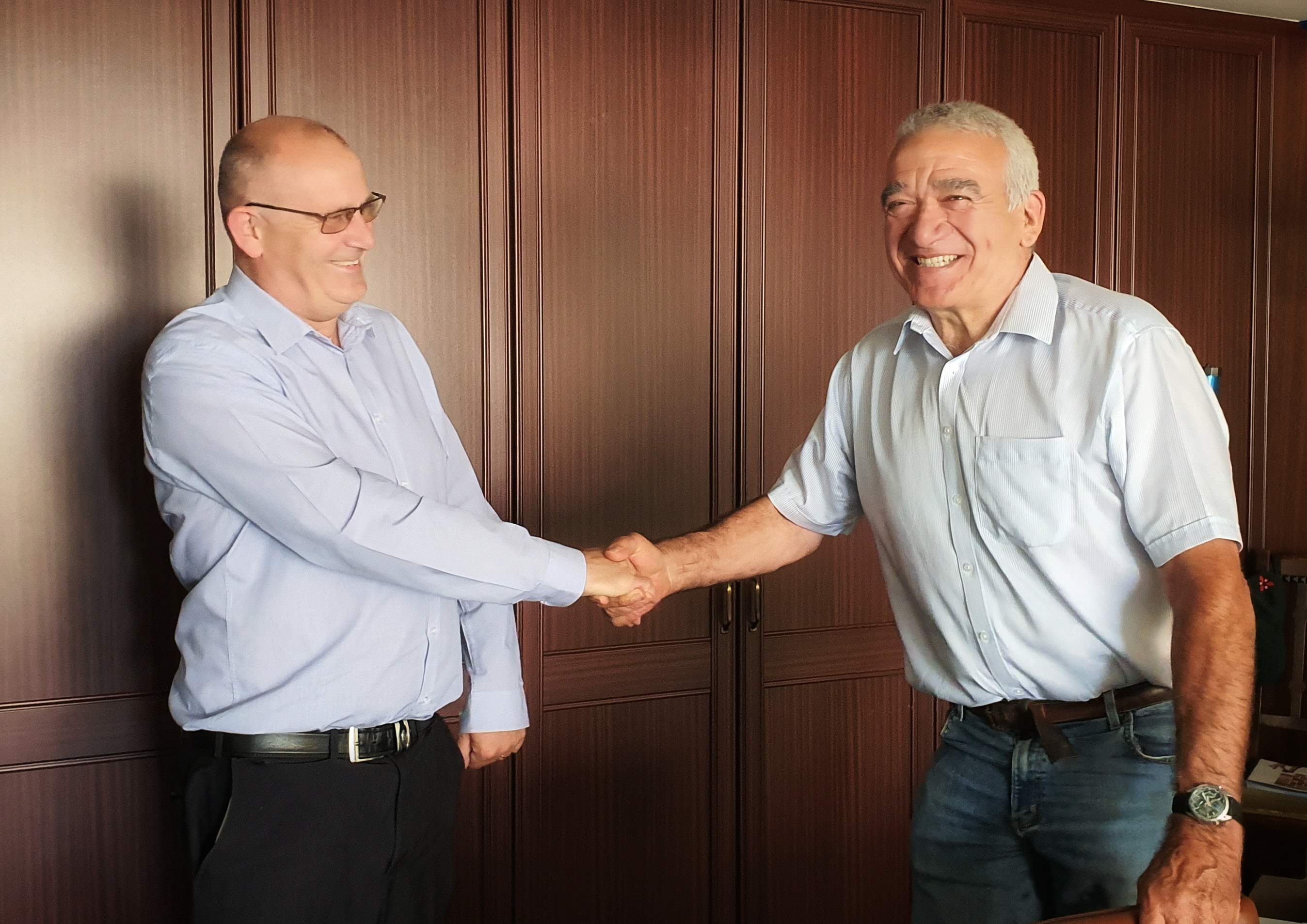 Richard Greetham congratulated by Robert Oldershaw for his long service award