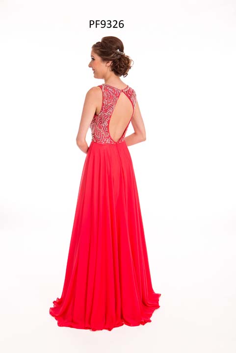 Prom girl wearing a strawberry red chiffon gown with silver beaded top, keyhole back and full skirt