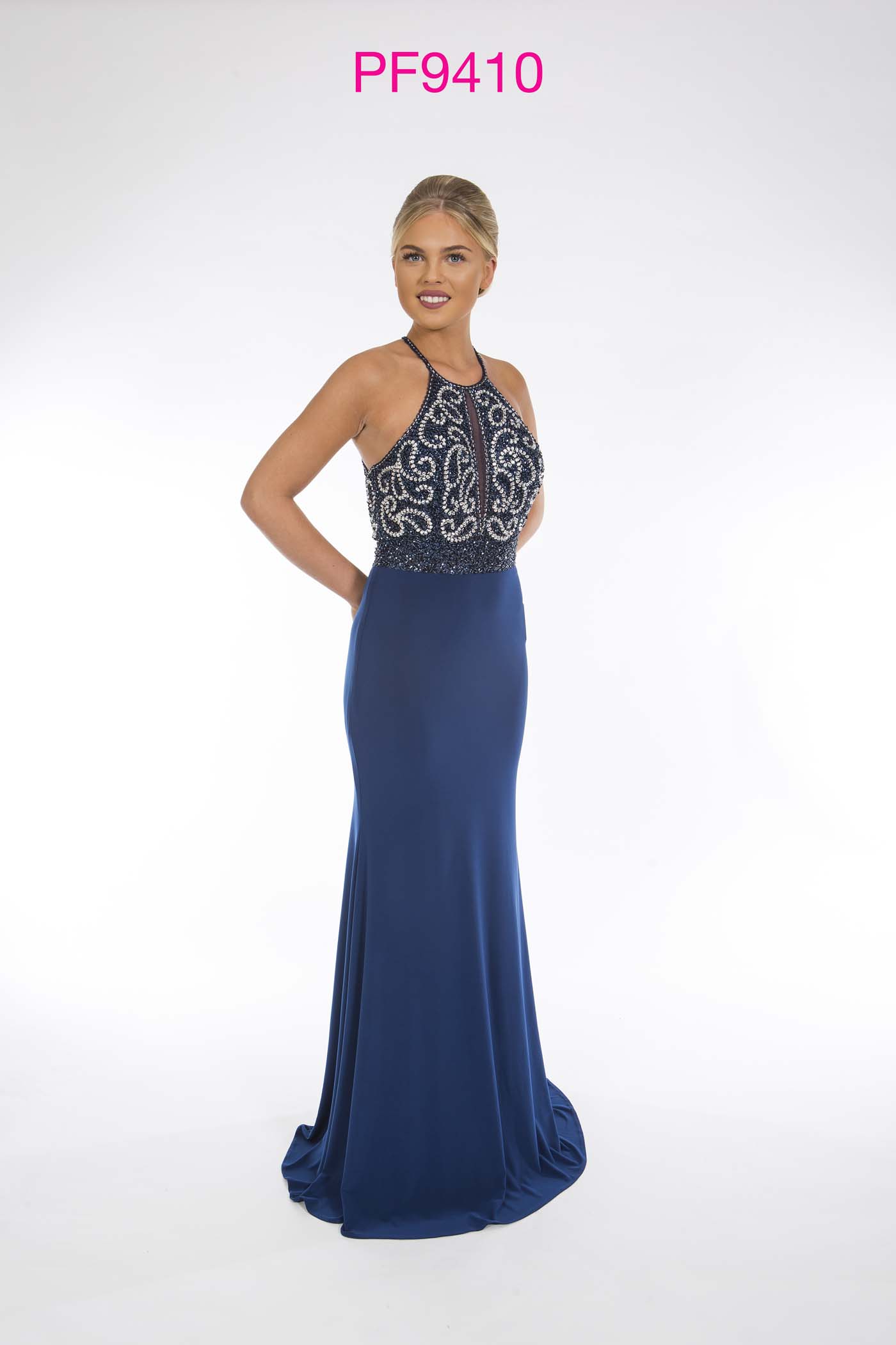 Prom girl wearing french navy fitted jersey gown with sliver beaded top and cross over straps at back.