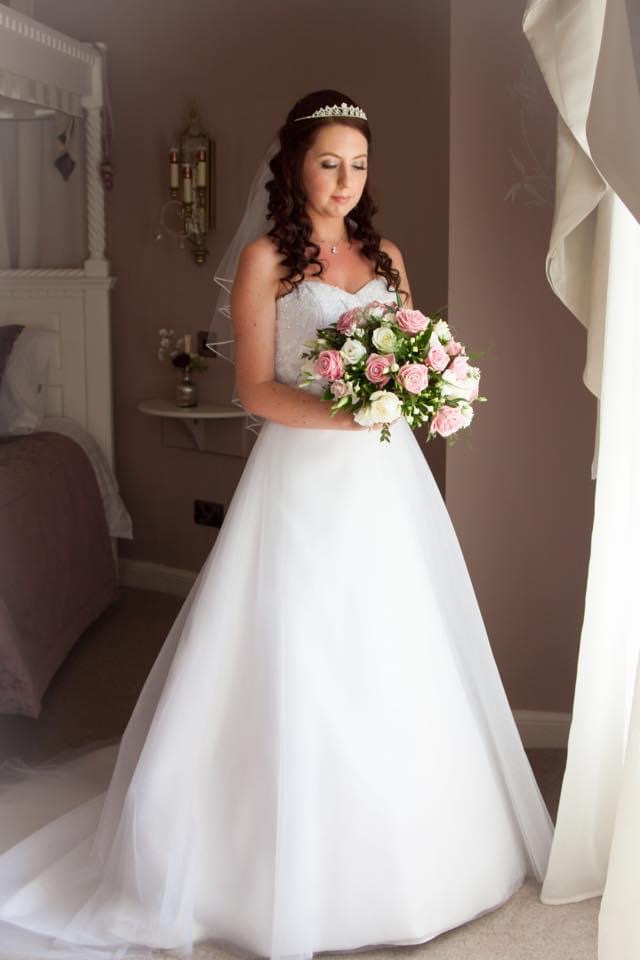 Bride wearing a white Aline gown with beaded sweetheart bodice and soft tulle skirt.