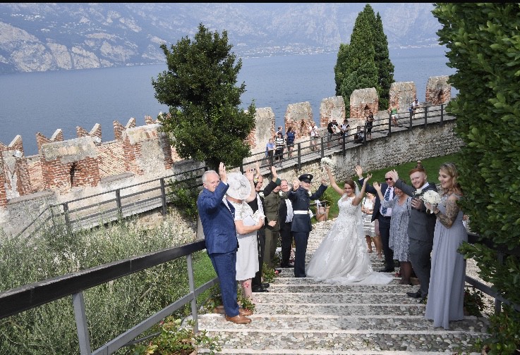 Bride and military groom on the steps overlooking Lake Garda.