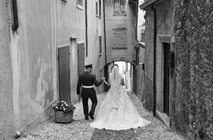 Bride and grrom strolling down a cobbled street in Lake Garda, Italy