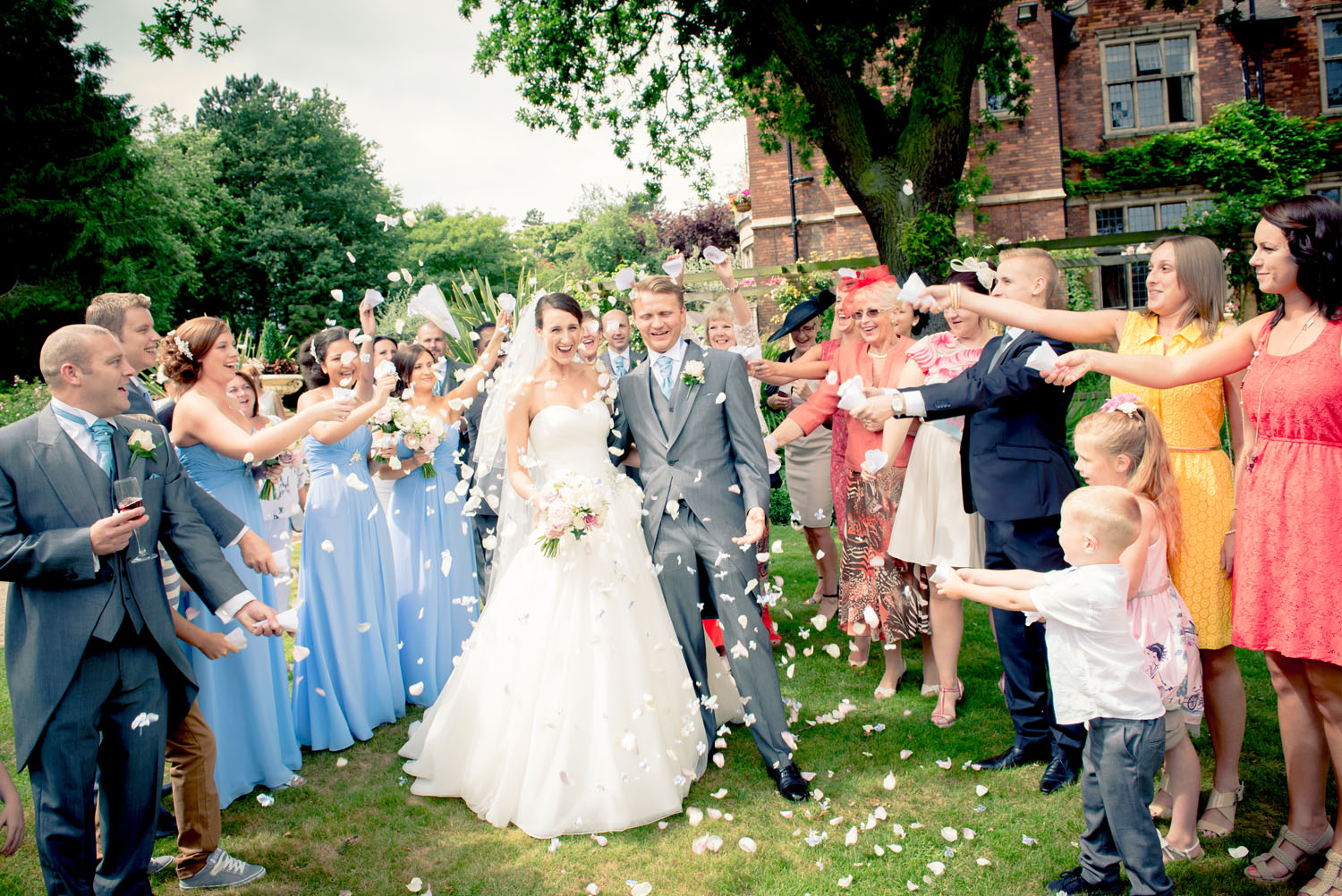 Bride and Groom being scattered in confetti by their gusts.