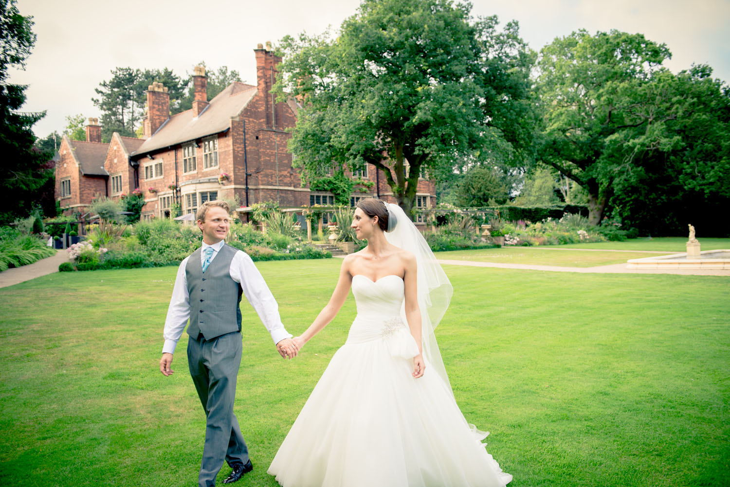 Bride and Groom waling together in the grounds of a hotel.