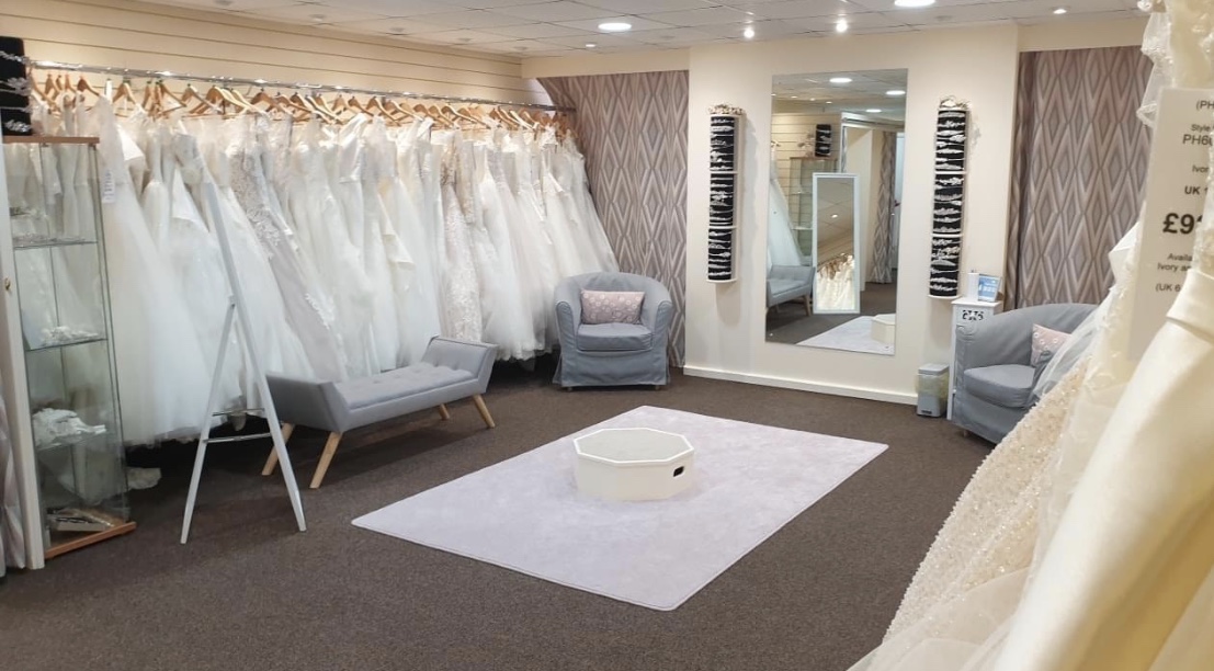 Bridal store interior, with gown rails and large mirror.
