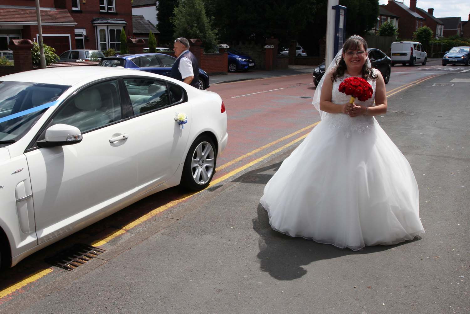 Bride arriving in style in her white wedding car.