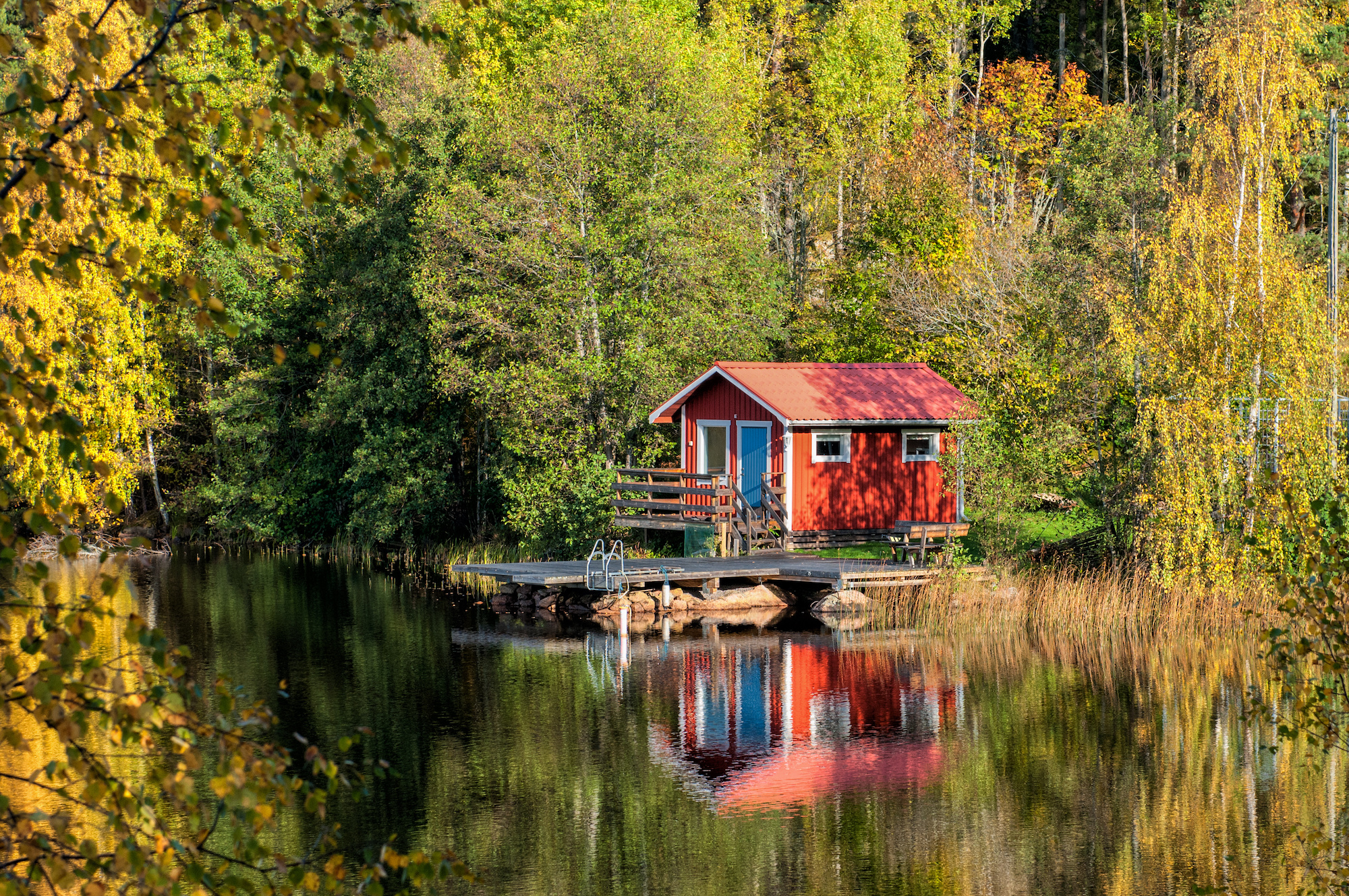 Cottage on lake with colourful trees