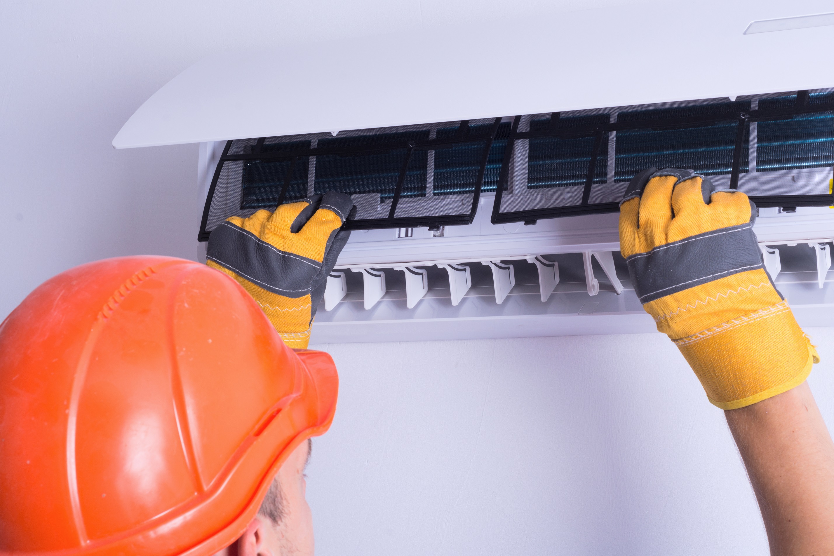 man changing filter on air conditioner