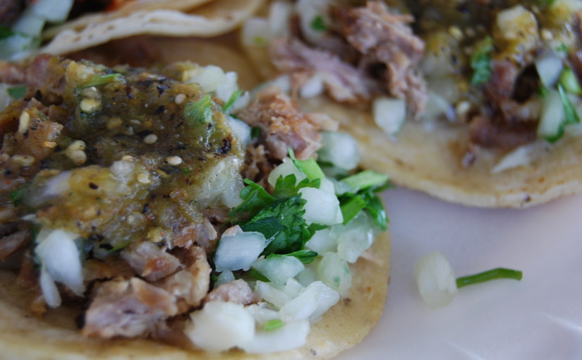 close-up of carnitas tacos with salsa on them
