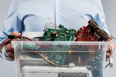 Man holding a plastic box with old electronics