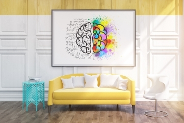 Colorful room with yellow sofa, teal table, white chair and a creative painting