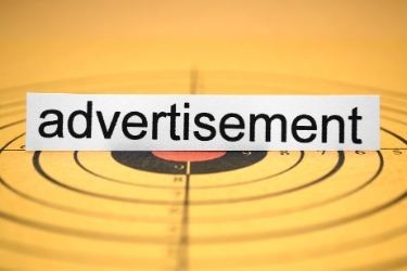 Paper with the word advertisement" on top of a bulleye