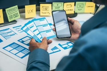 Man working on user's experience website layouts on mobile version