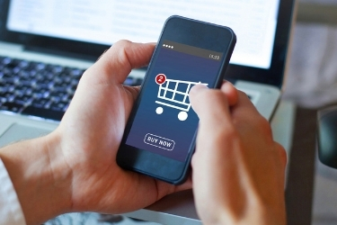 Hands holding a mobile phone with a purchase screen