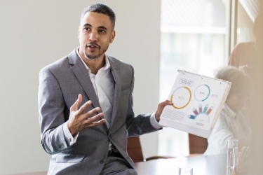 Man talking about the opportunities while holding sales graphics