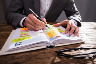 Man writing in an agenda