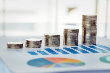 Coins stacked next to a financial graphic