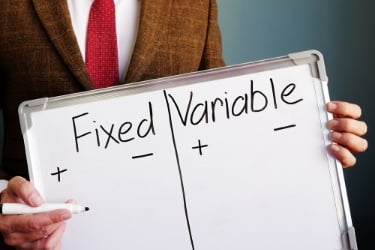 Man holding a whiteboard with the word Fixed and Variable