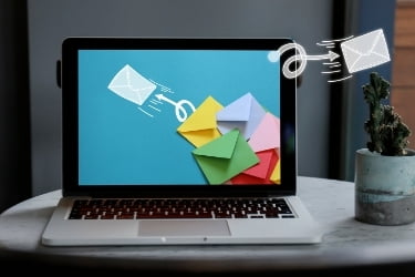 Email Blast Concept - Email letters flying out from the laptop