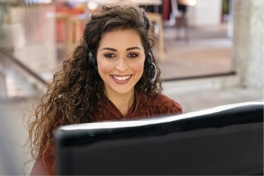 Woman with a headset sitting in front of a computer