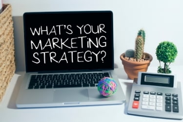 Laptop with the text "What's your marketing strategy?"