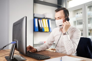 Man working on telemarketing with a face mask