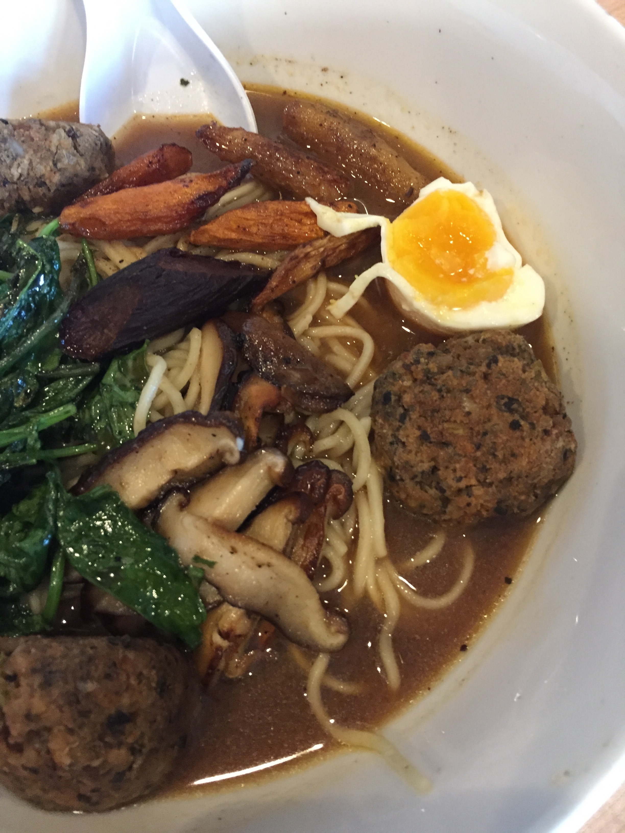 Ramen with caramelized corn miso dash, shiitake, baby kale, coffee roasted carrot, duck egg with optional vegan meatball
