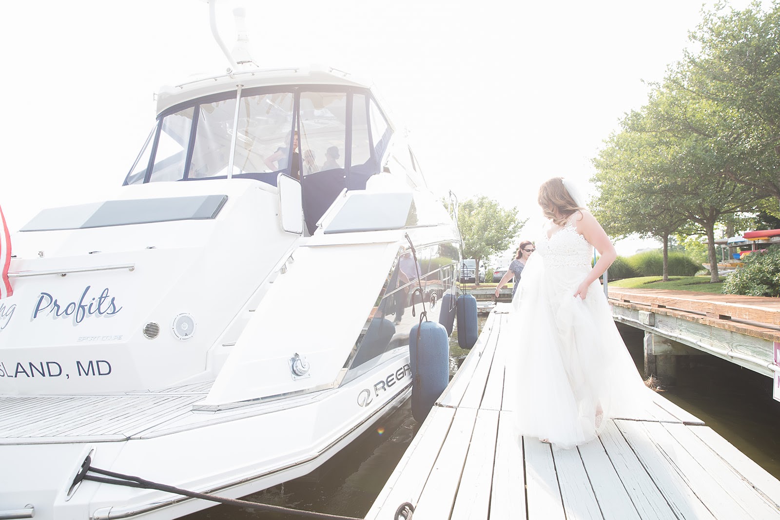 bride in wedding gown walking toward boat