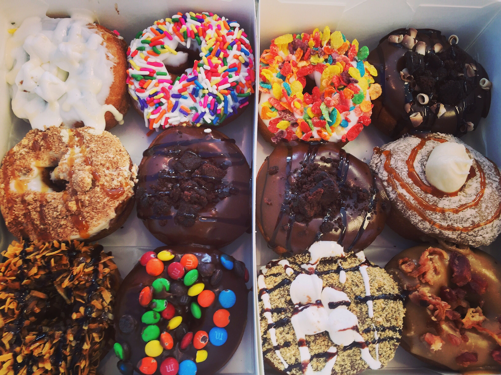 box of a dozen colorfully decorated donuts