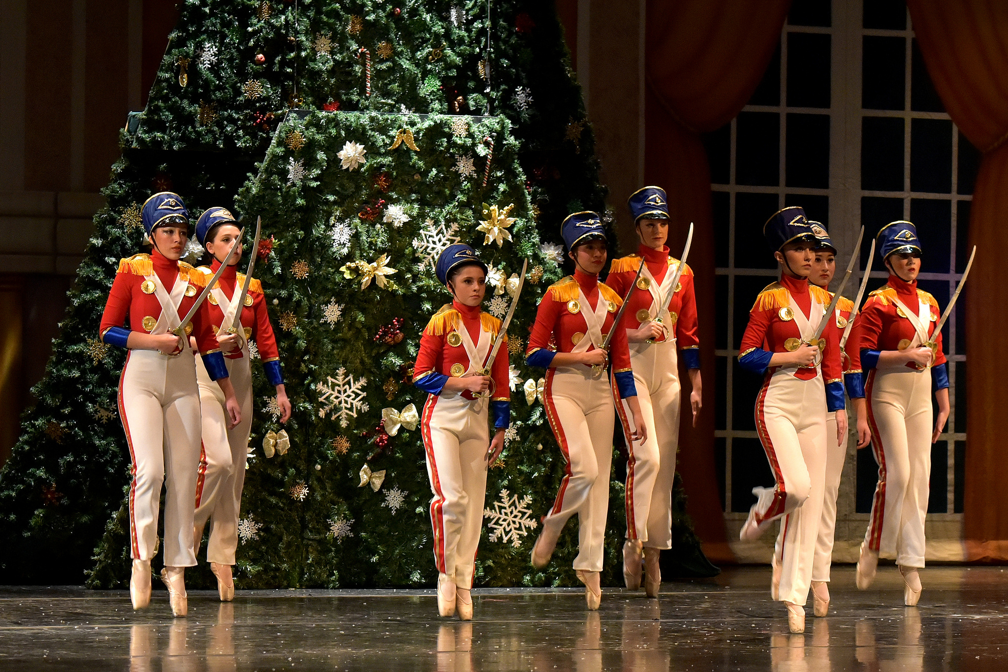 holiday soldiers dance in front of christmas tree for holiday performance