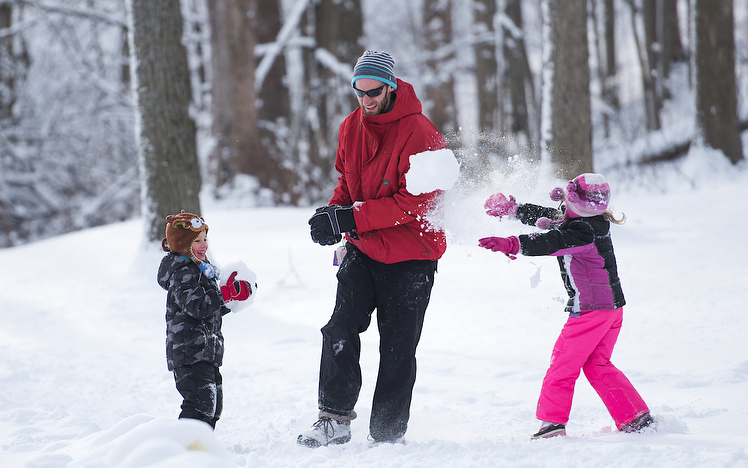 family playing together with snow
