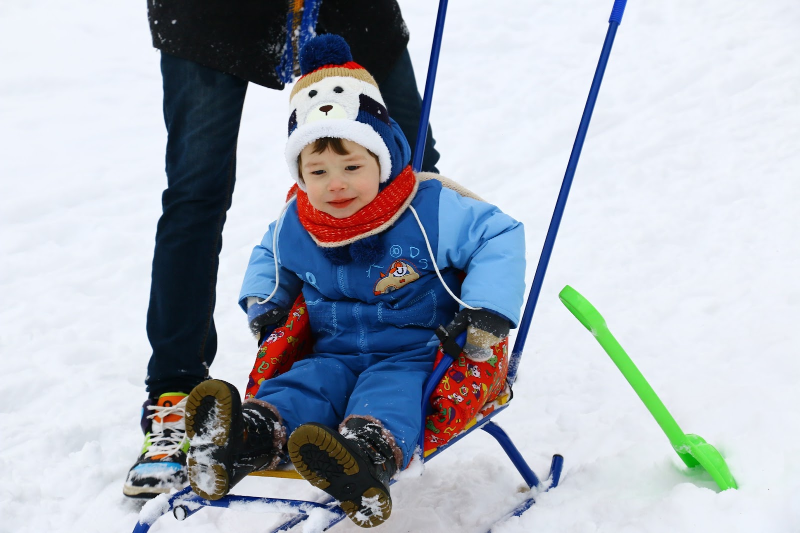 little boy sitting on sled in the snow