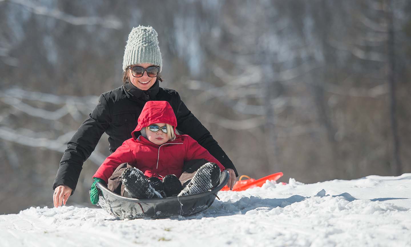 mother & child sledding in snow at Cleveland Metro Park