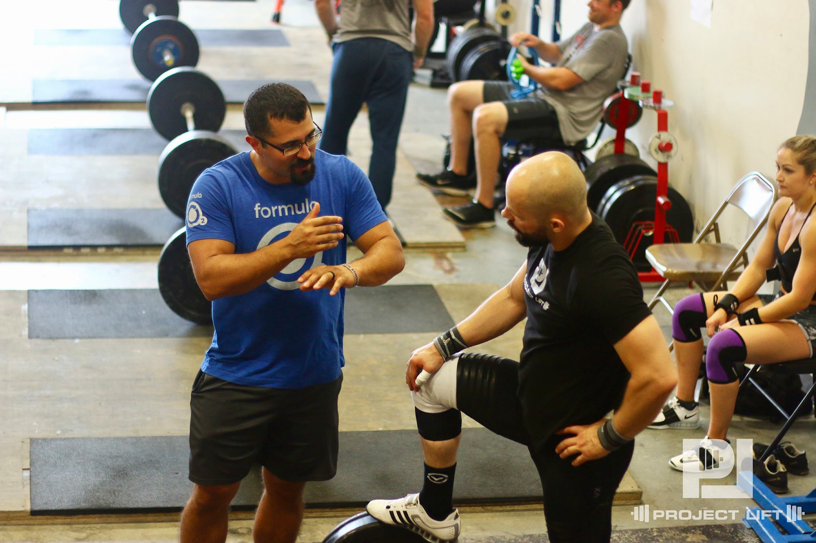 Men discussing lifting at gym