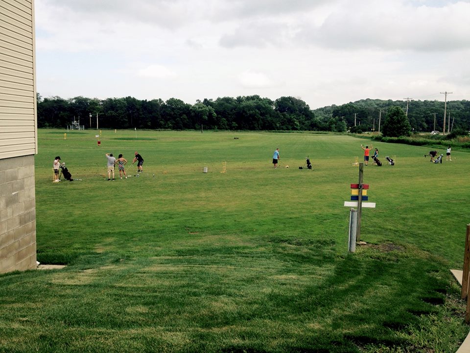Driving range with various golfers