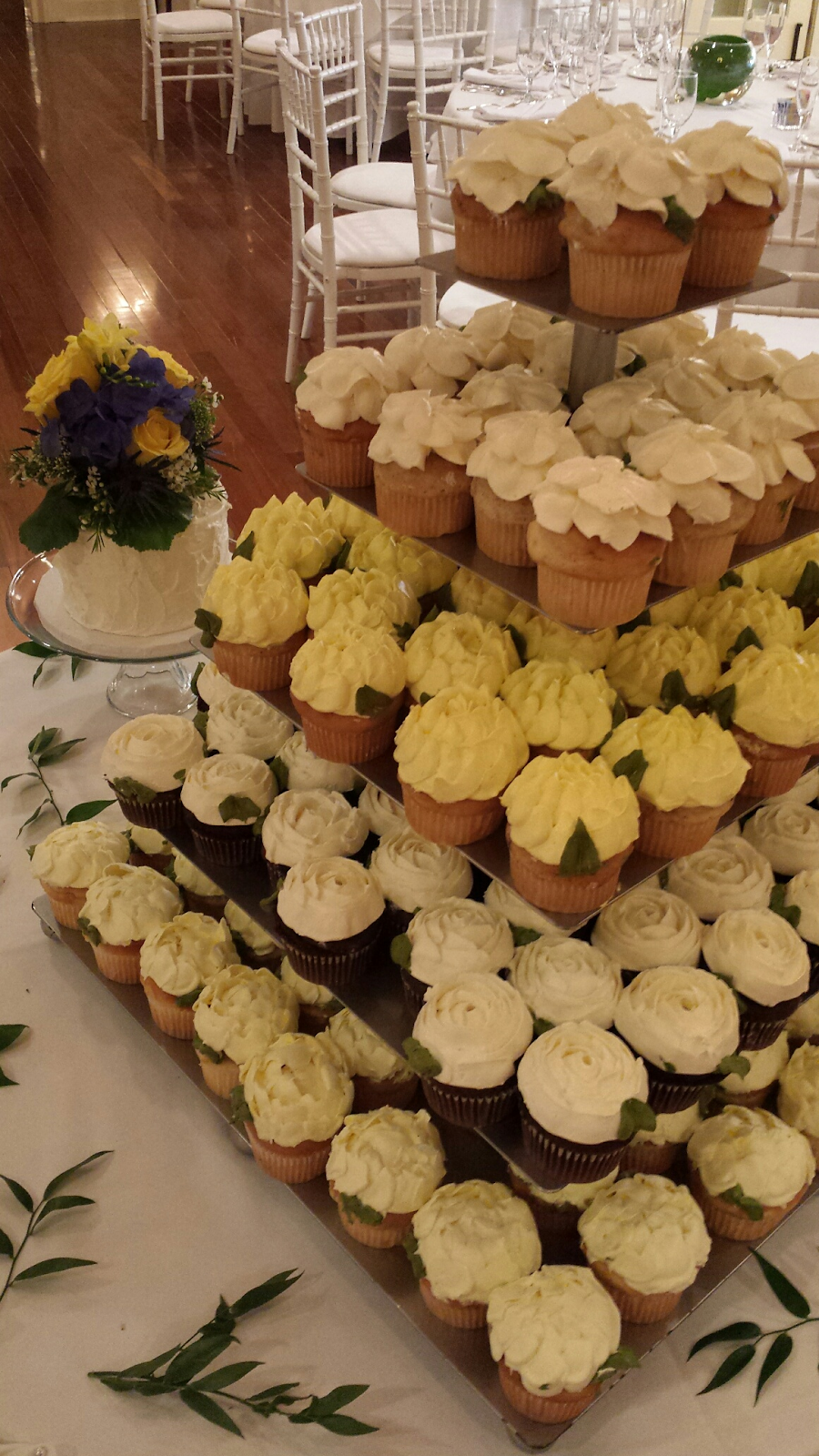 display stacking dozens of white and yellow cupcakes