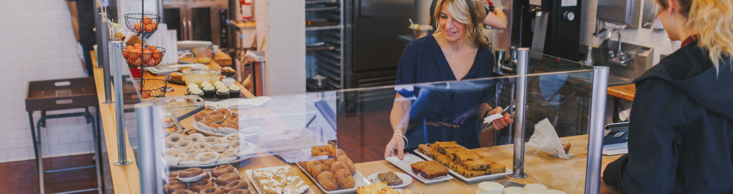 woman looking at pastries behind glass