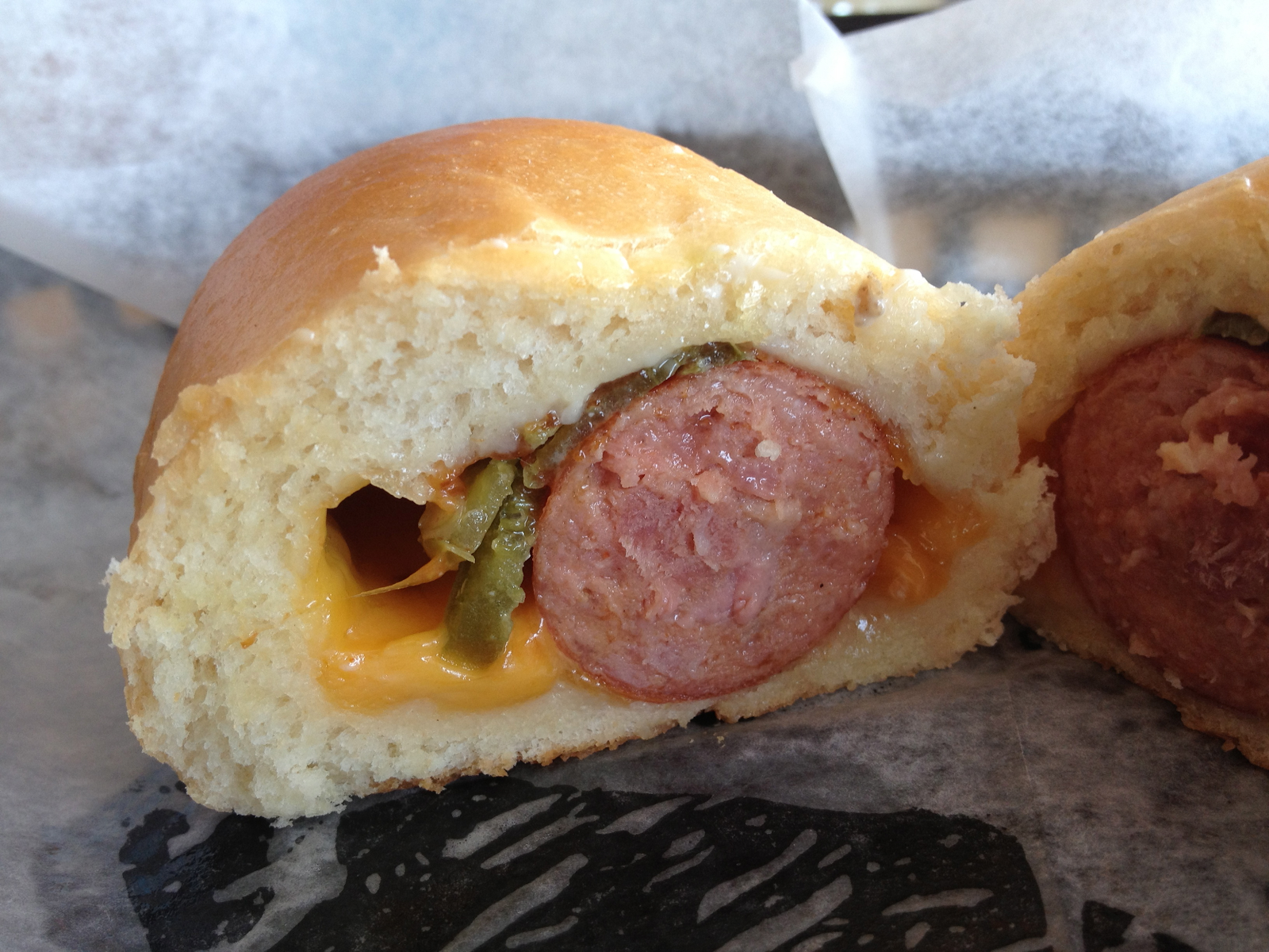 close up of pastry cut in half with sausage and cheese inside