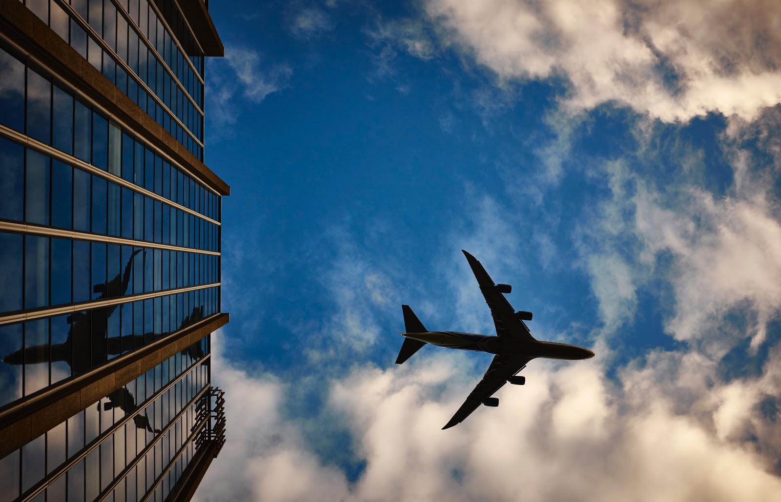 ground view of airplane flying over building