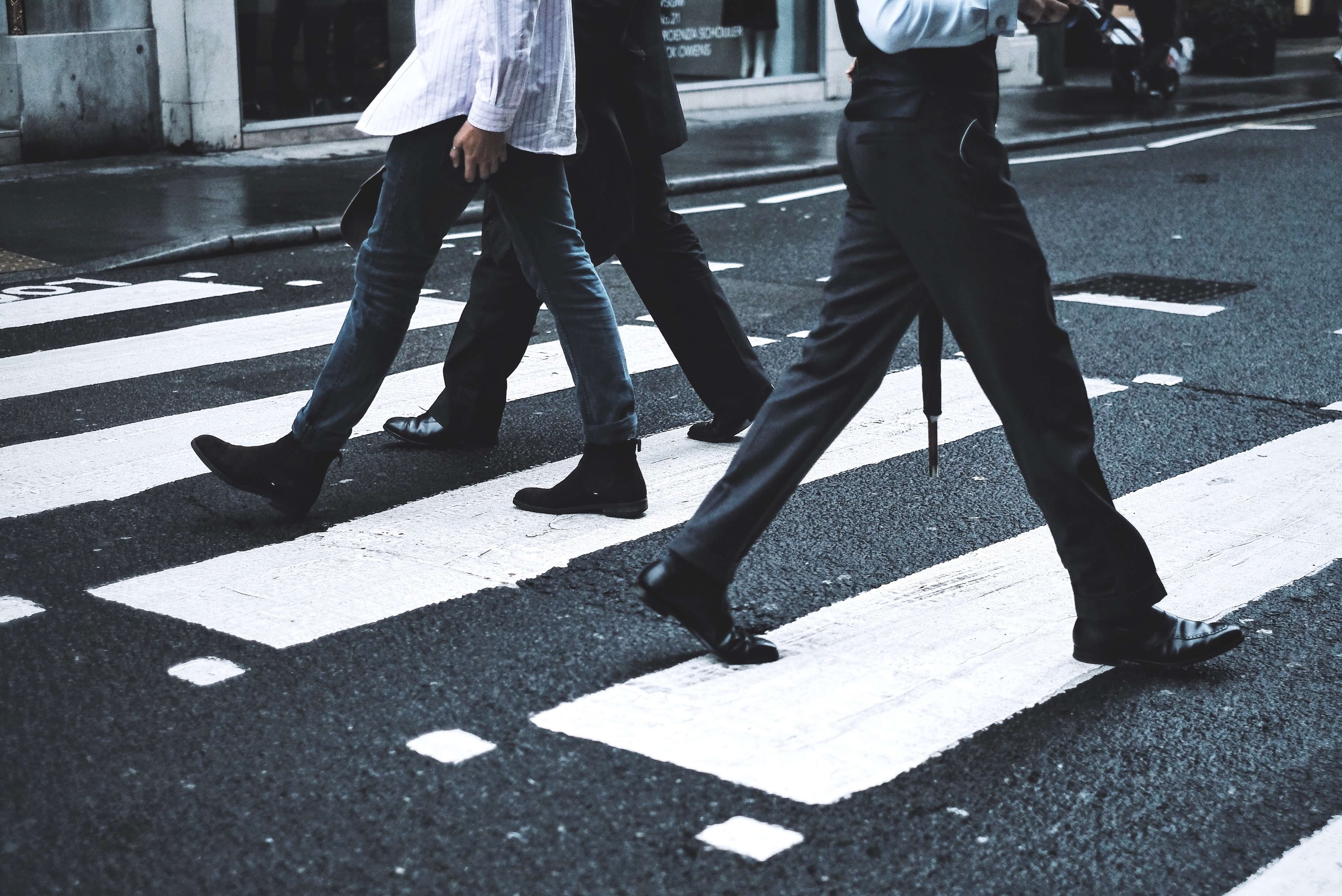 Pessoas caminhando pela faixa de pedestres