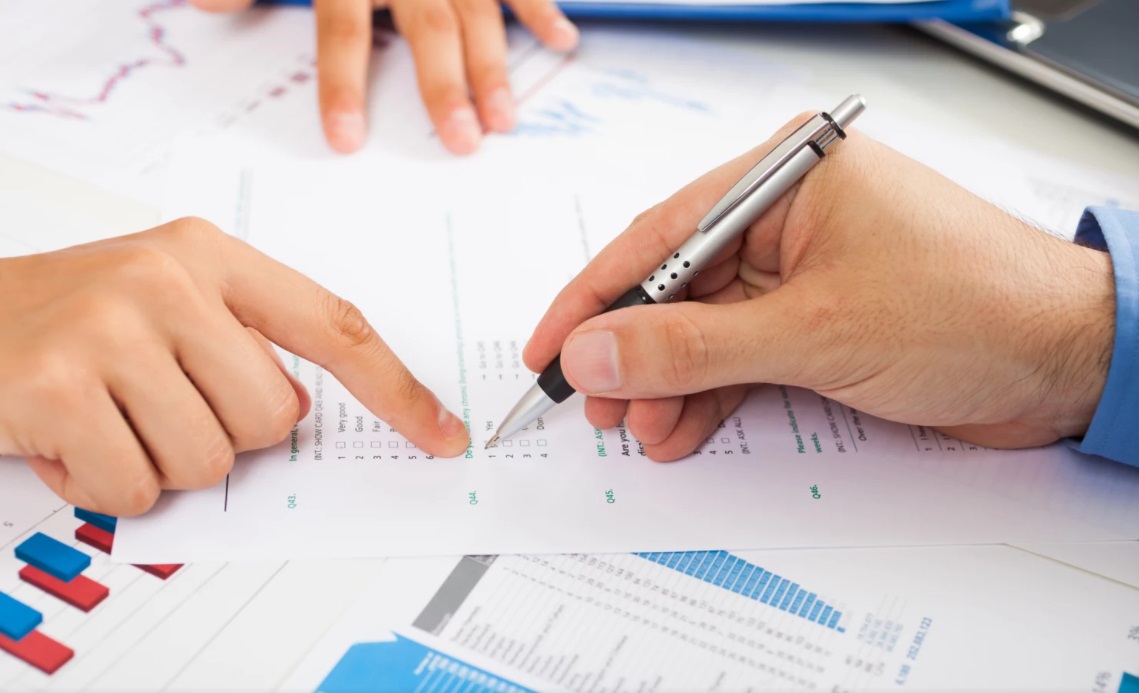 Mãos preenchendo formulário de satisfação