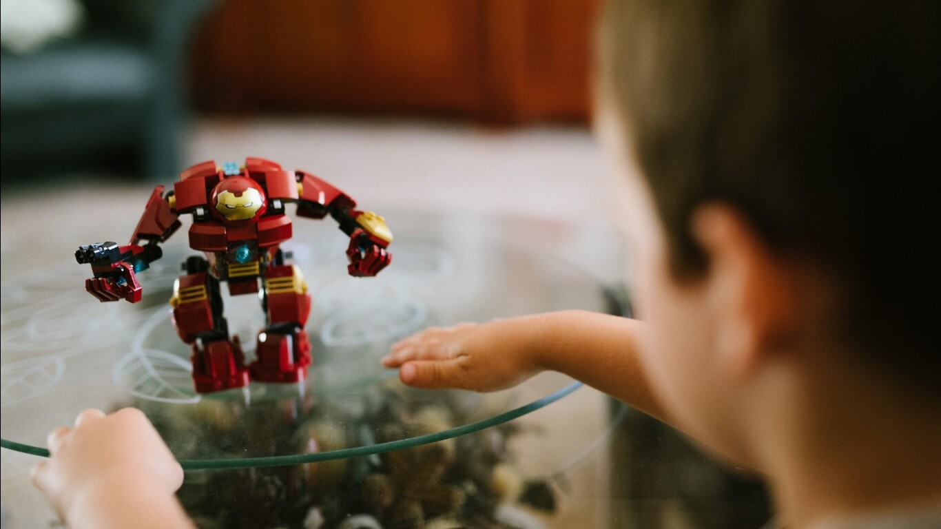 Garoto brincando com boneco do Homem de Ferro