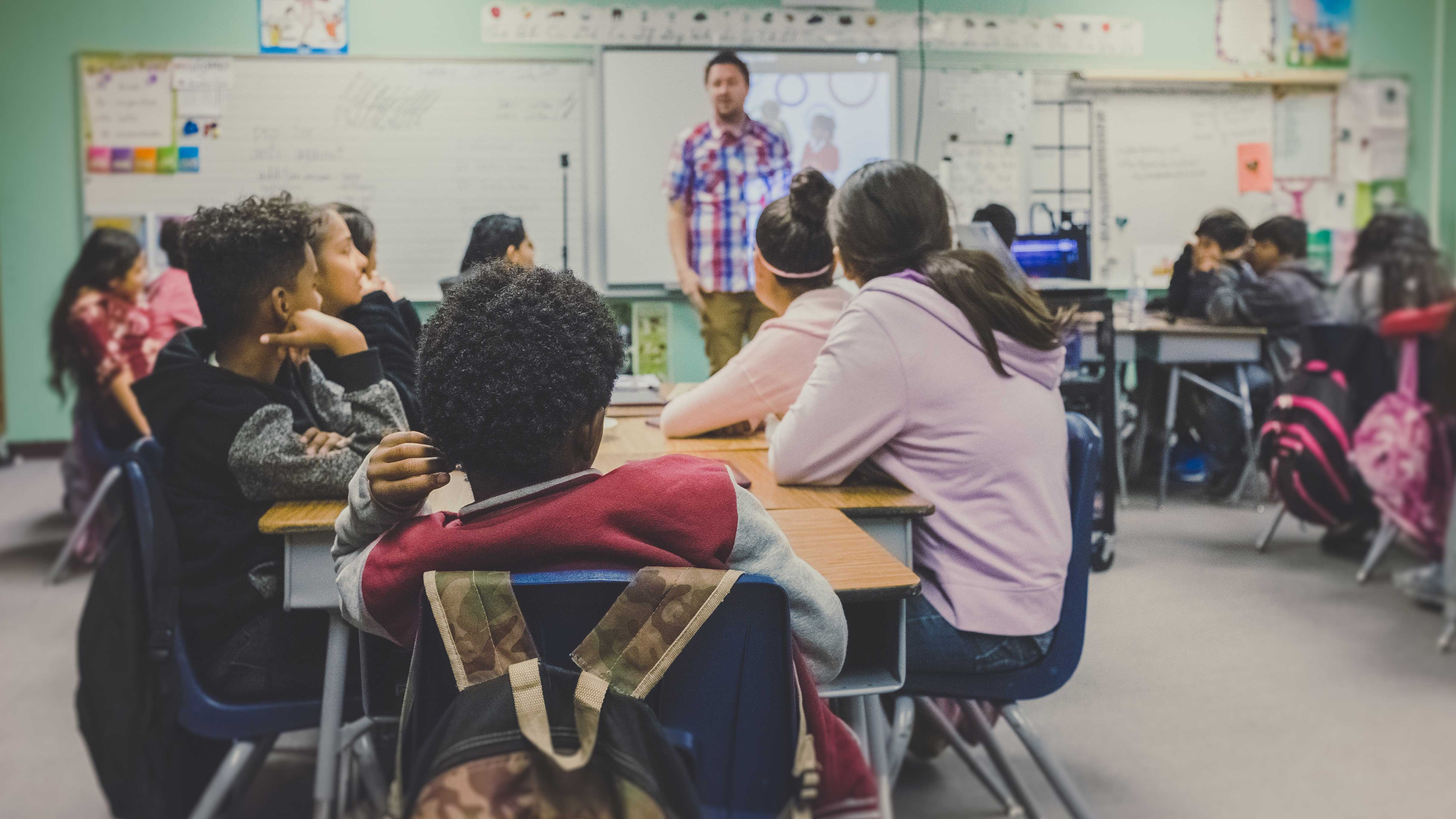 Alunos organizados em grupos na sala de aula
