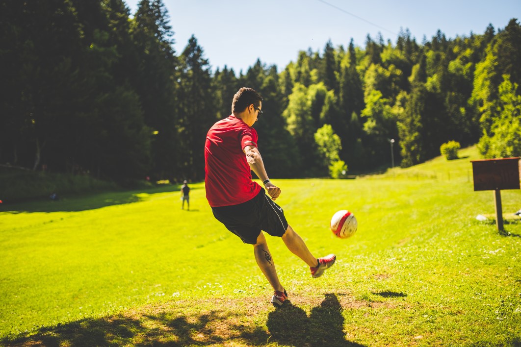 Rapaz jogando futebol em parque