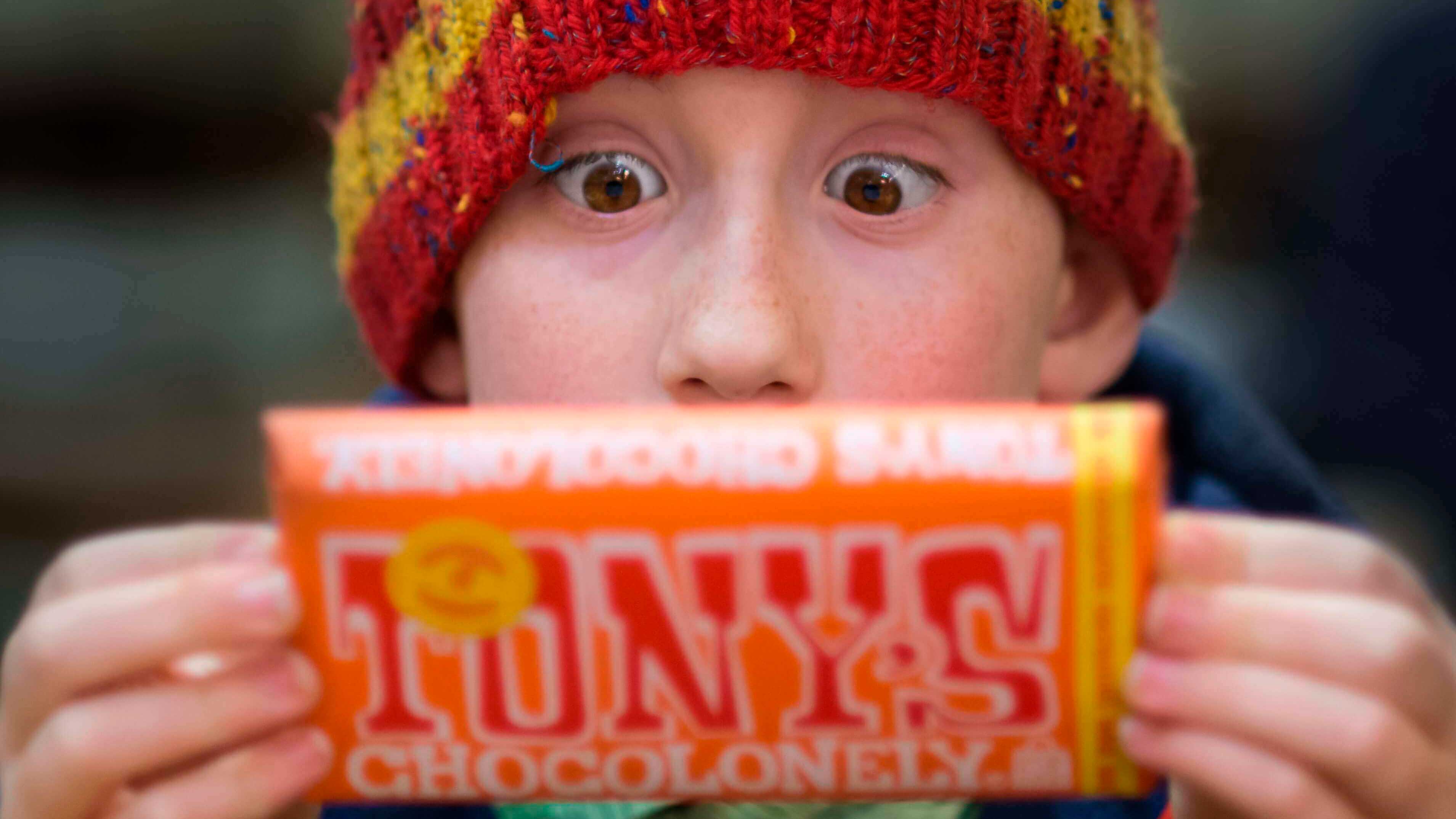 Meu filho não me obedece — Como posso fazer com que ele me ouça? - Mneino surpreso segurando barra de chocolate