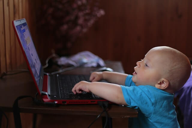 Bebê brincando no notebook