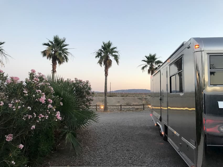Aluminum Travel Trailer in front of palm trees
