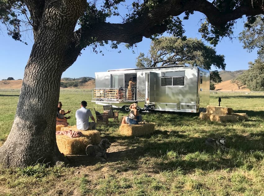 People hanging outside an off-road travel trailer