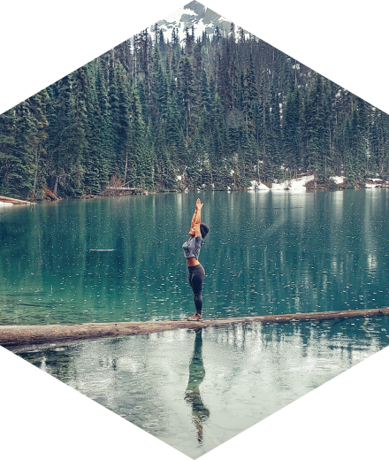 girl balancing on a log in a lake