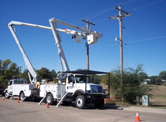 Bucket trucks with boom extended assisting in power restoration